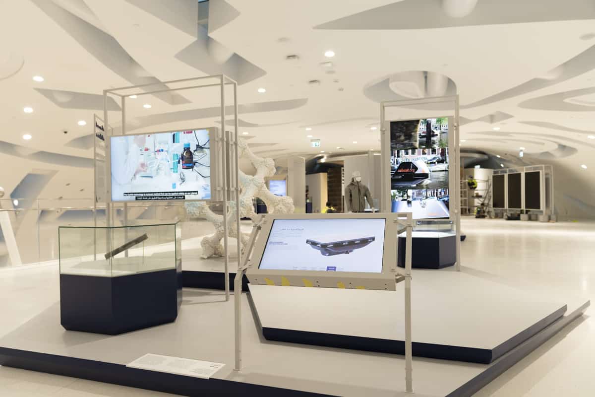Modern exhibition space with interactive digital displays, curved architecture, and a blend of tech and art installations.
