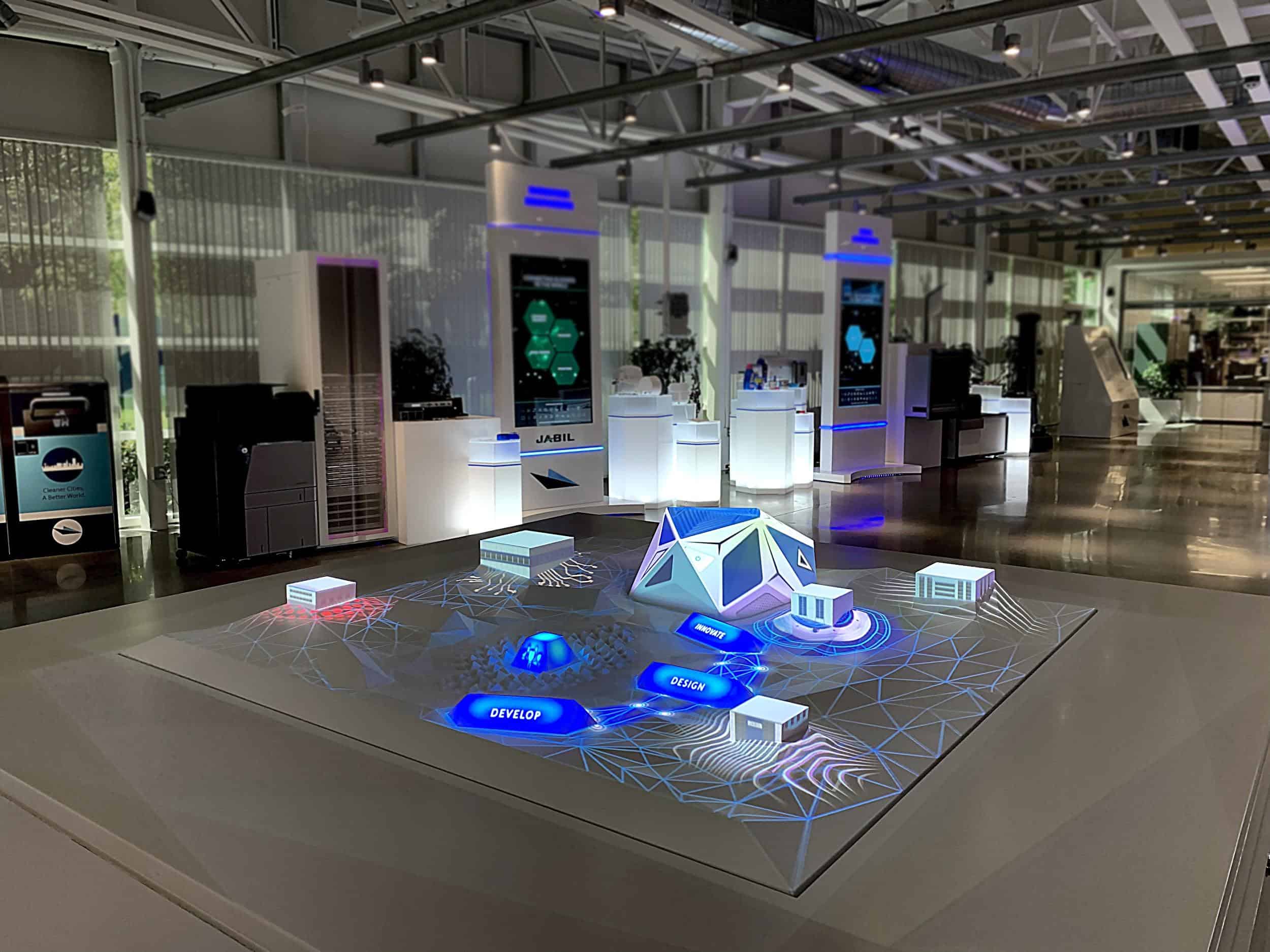 A futuristic exhibition space with a central digital model, illuminated shapes, Develop & Study labels; sleek, bright design.